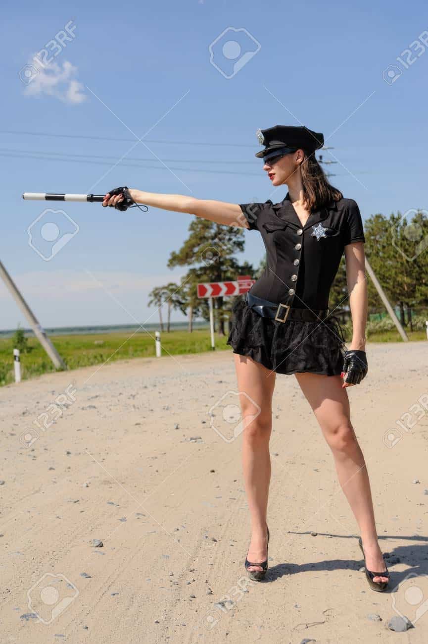 Sexy police woman on road shows stop gesture